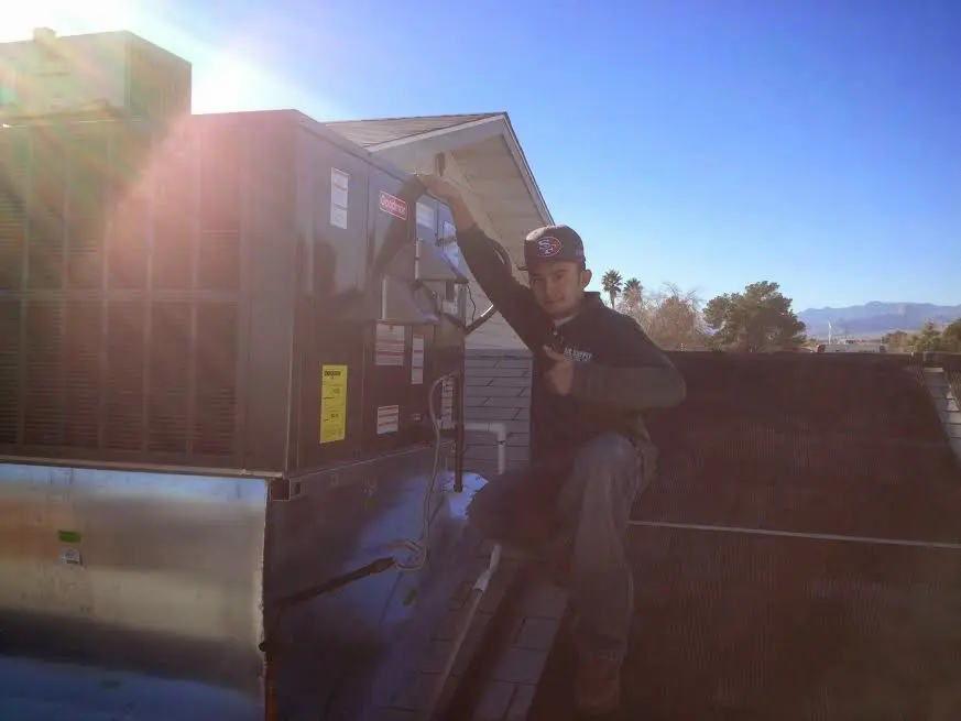 HVAC technician performing Boiler Repair on a rooftop unit in Gladstone
